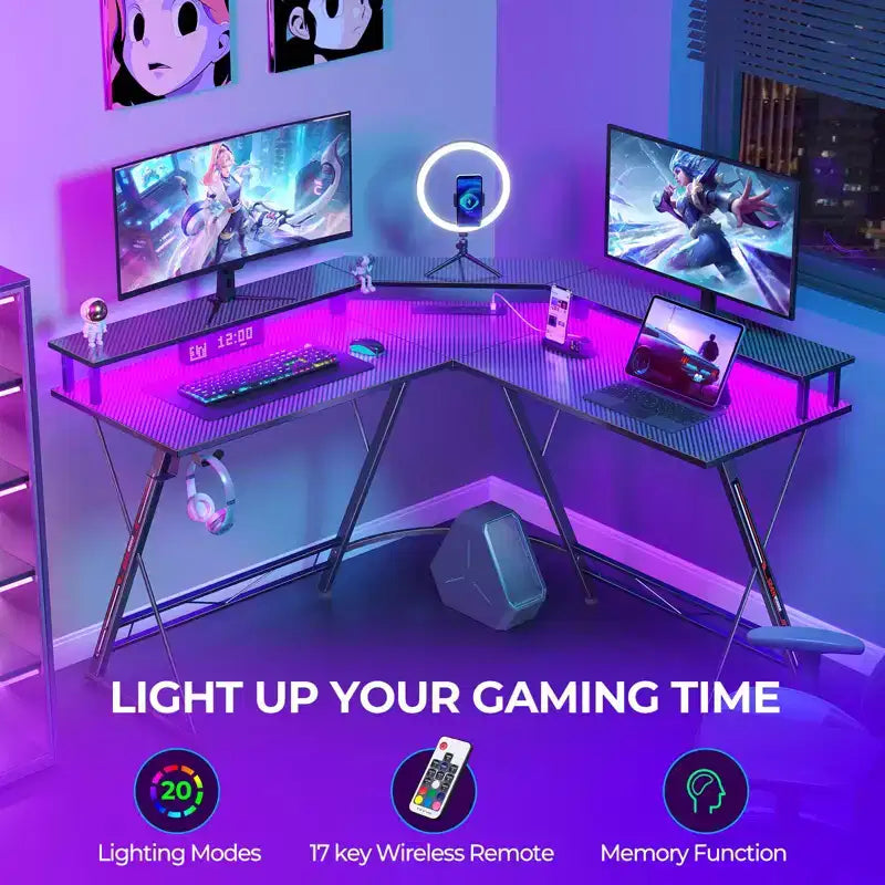 Scrivania a L Greenstell 128 cm – Superficie in fibra di carbonio con luce LED e prese di corrente, tavolo da gaming con supporto per monitor e gancio per cuffie
